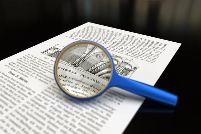 Loupe à manche bleu posée sur une page de texte imprimé
