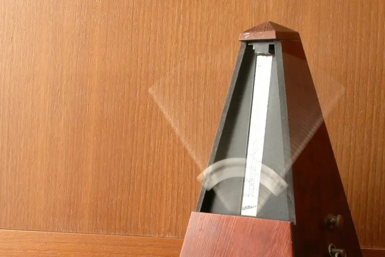 Métronome mécanique en bois, balancier en mouvement
