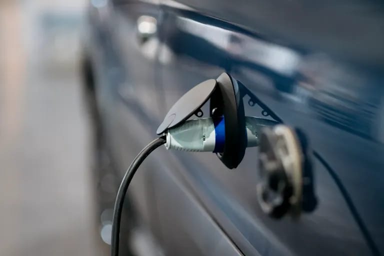Câble de recharge branché sur la trappe d'une voiture électrique