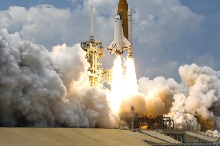 Décollage de la navette spatiale Atlantis dans un panache de fumée
