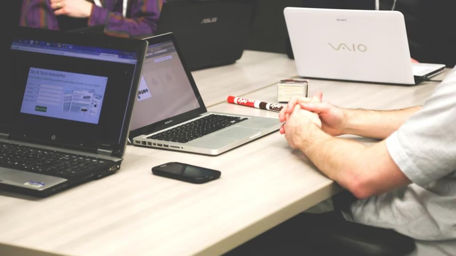 Équipe diverse réunie autour d'une table de travail, esprit de communauté et d'entraide