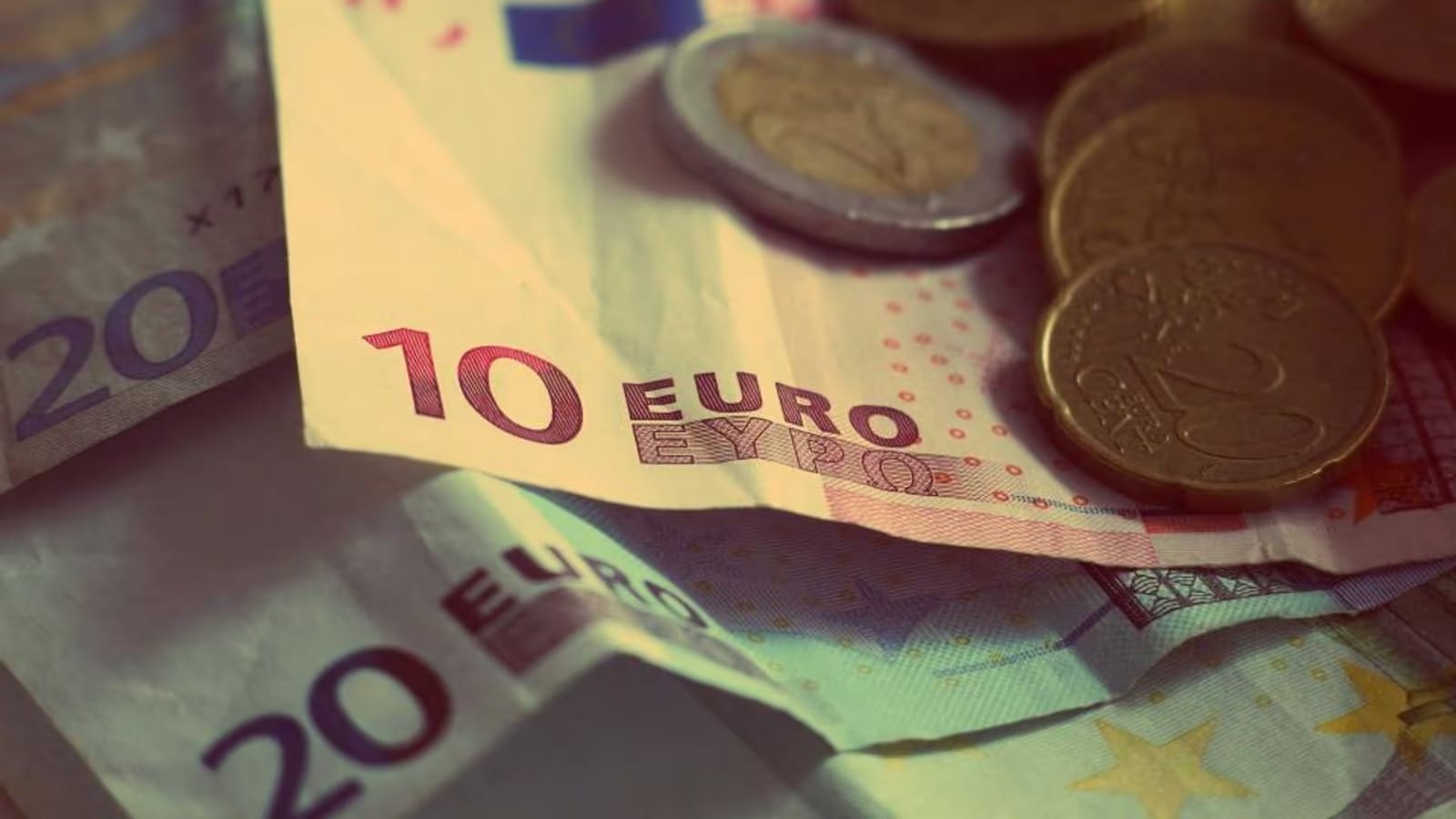 Billets et pièces en euros posés sur une table, illustrant l'épargne et l'investissement