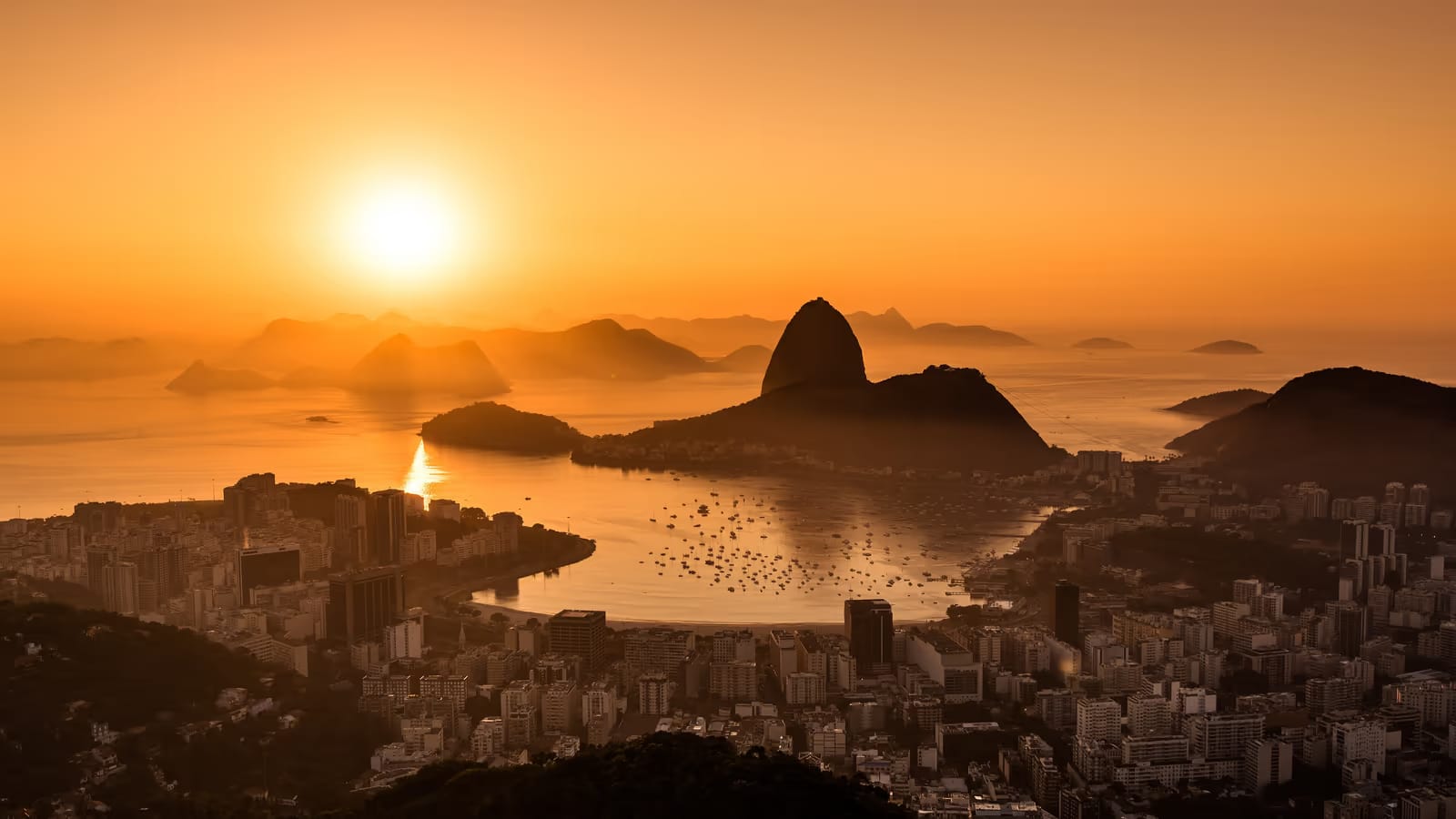 Sommet de montagne au lever du soleil dominant un horizon dégagé, évoquant l'ambition et la mission