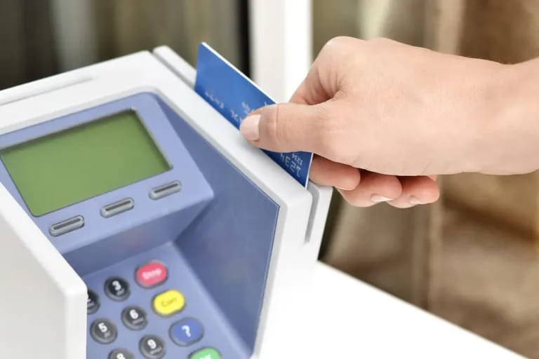Main insérant une carte bancaire dans un terminal de paiement