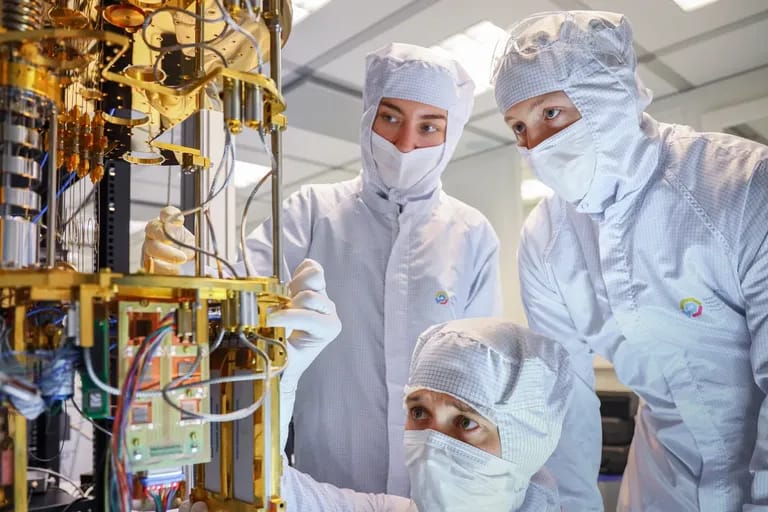 Chercheurs en salle blanche assemblant un processeur quantique cryogénique doré